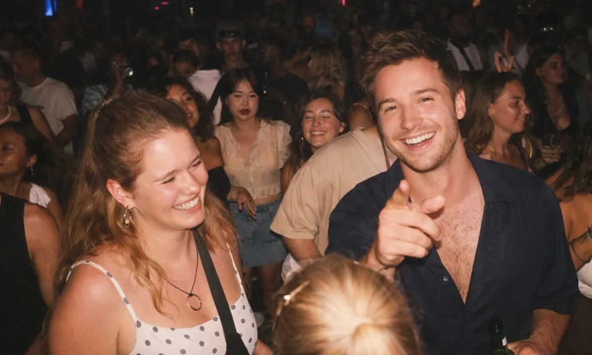 Two interns laughing in a crowd at an evening event in Bali