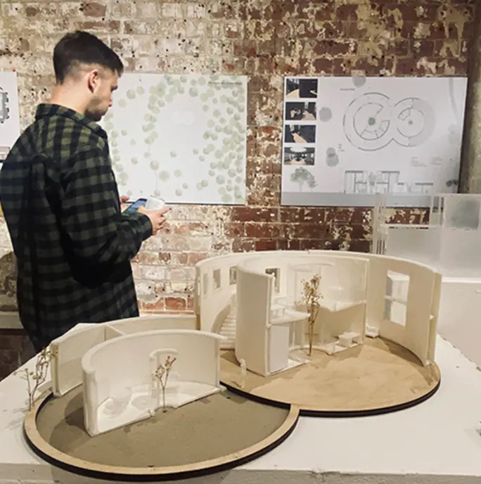 A designer reviewing an interior model and spatial plans