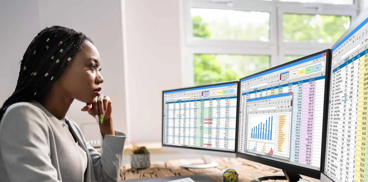 An analyst reviewing dashboards across multiple screens