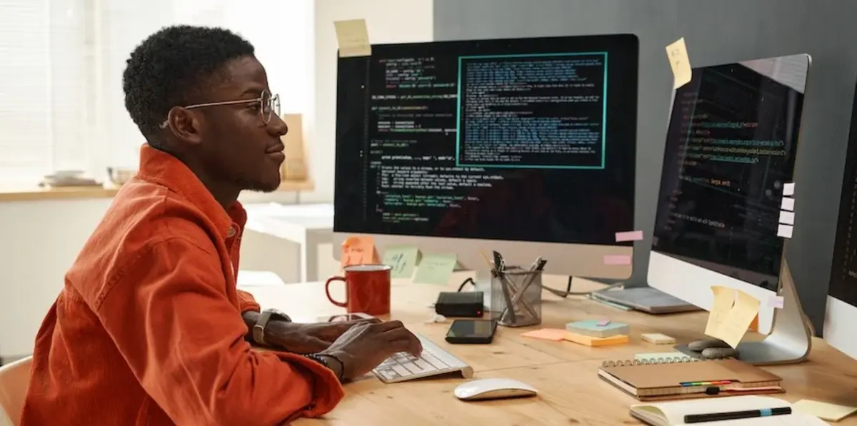 A developer working across two code screens