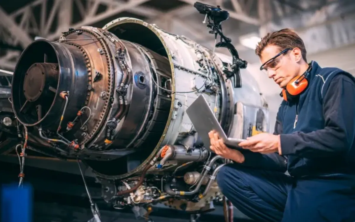 An engineer inspecting an aircraft engine